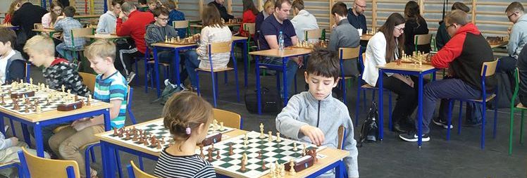 Dwoje maluchów przy szachownicy w trakcie zawodów