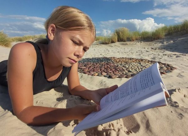 Dziewczynka z książką na plaży