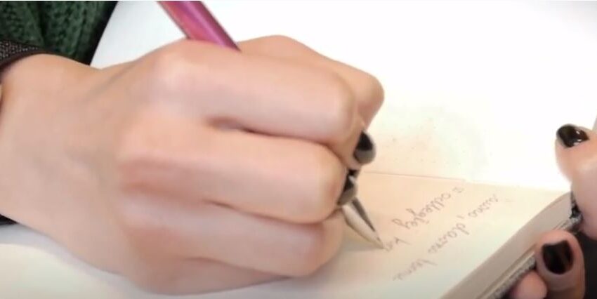 damska ręka z długopisem, notatnik