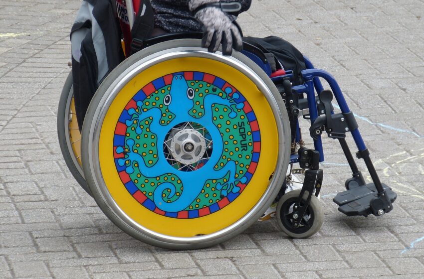 wózek inwalidzki z turkusowo-żółtym kołem