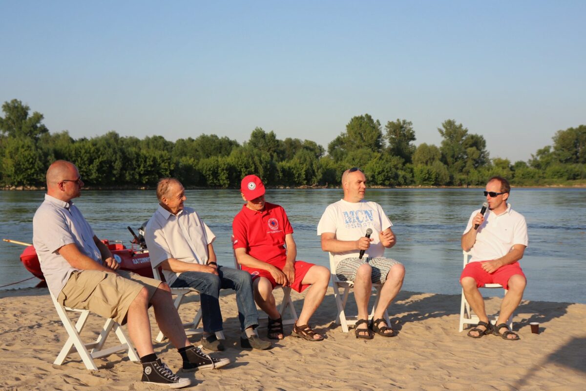 pięciu panów na krzesłąch na plaży