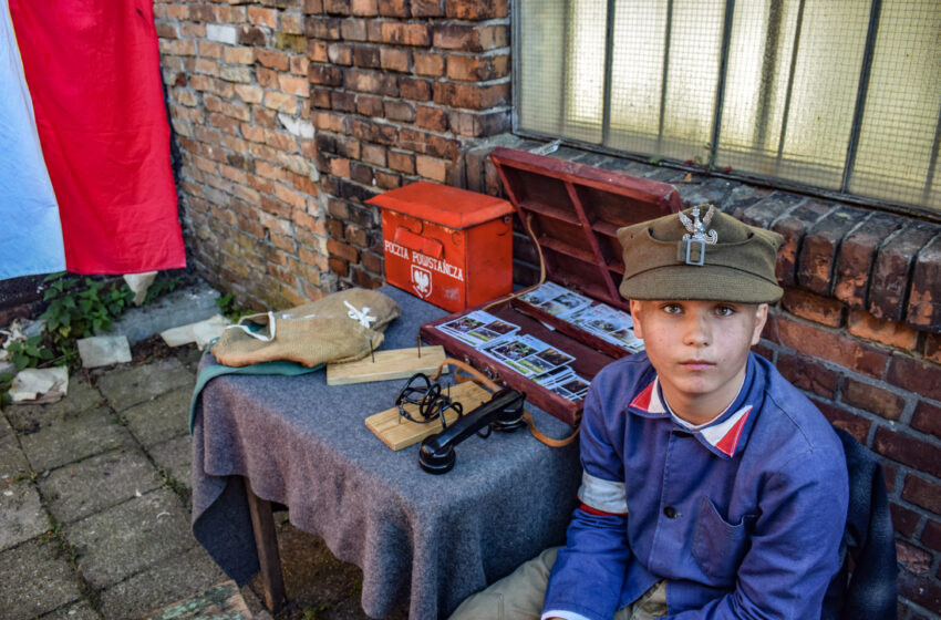 chłopiec przeprany za małego powstańca patrzy w obiektyw