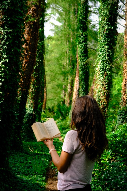 dziewczyna z książka wśród drzew