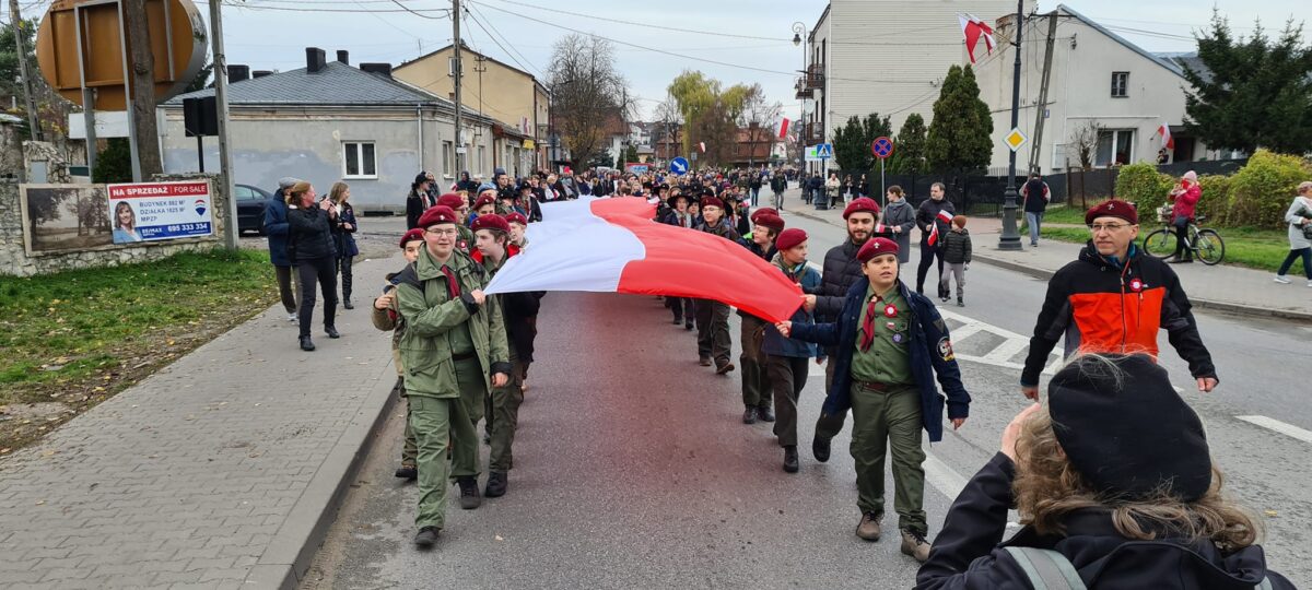 dzieci niosą wielką flagę