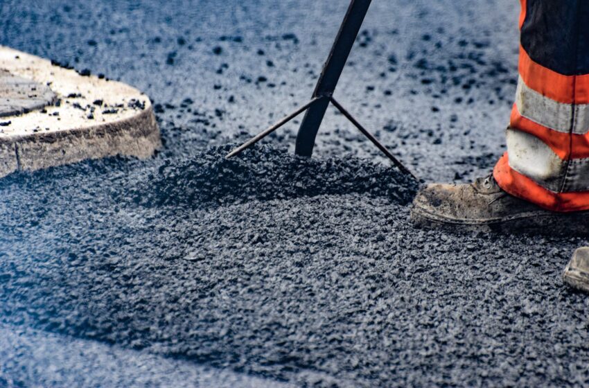 asfaltowanie, but, robotnik kładzie masę bitumiczną na drodze0