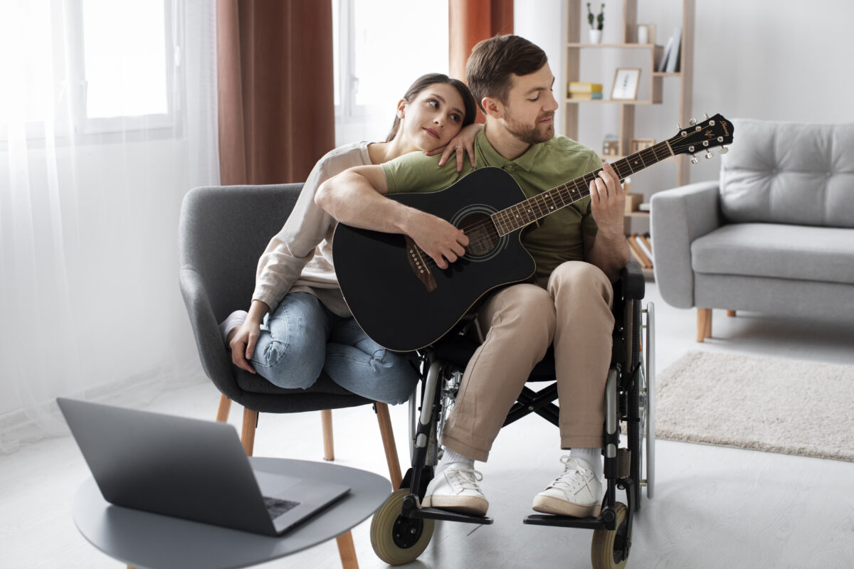młody człowiek na wózku inwalidzkim z gitarą
