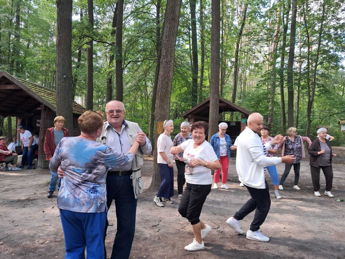seniorzy tańczą na polanie
