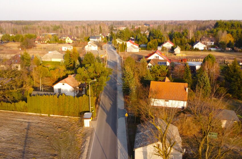 droga z lotu ptaka, drzewa, domy po dwóch stronach