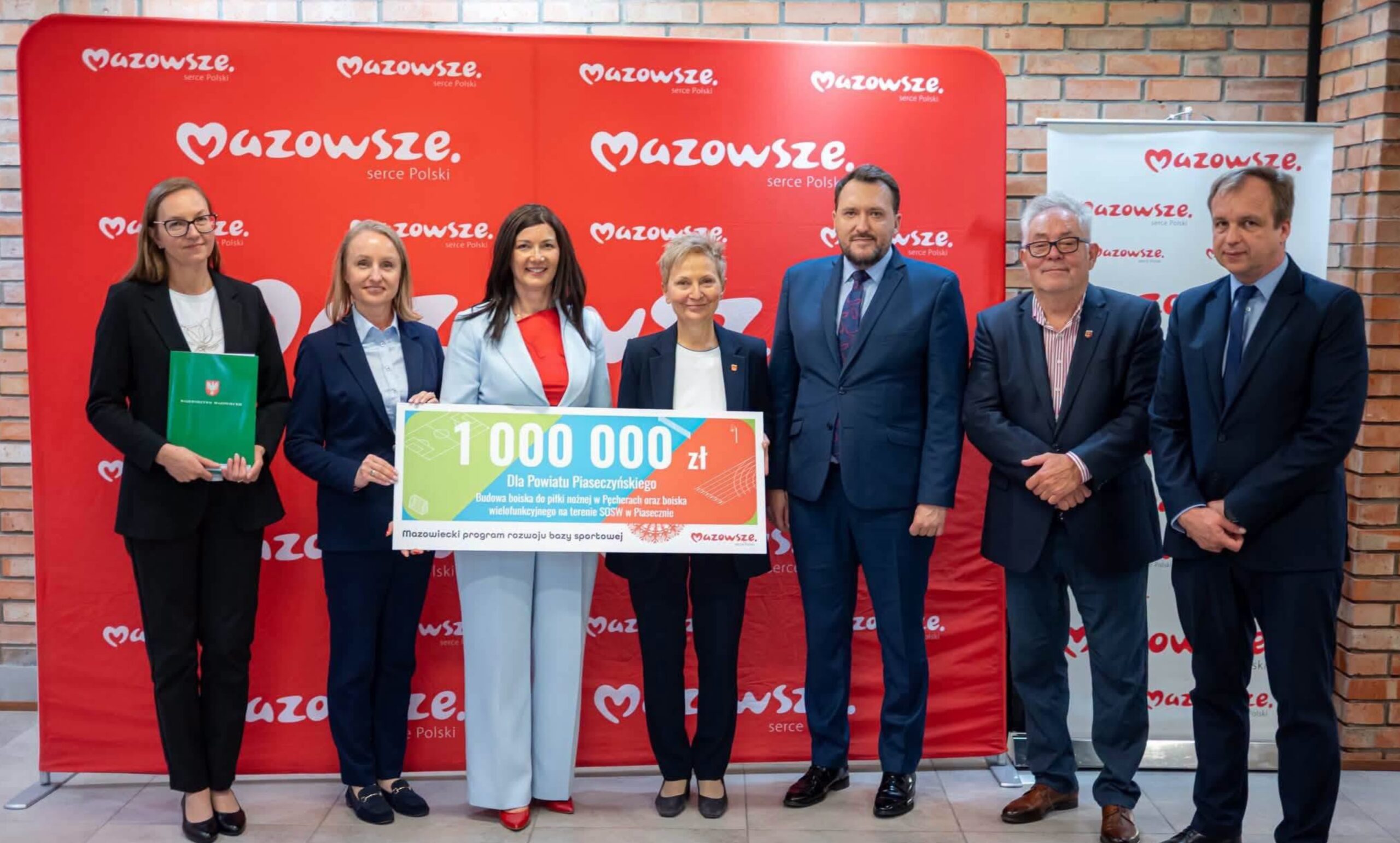 delegacja odbierajaca symboliczny czek