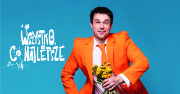 aktor w pomarańczowej marynarce na biebieskim tle